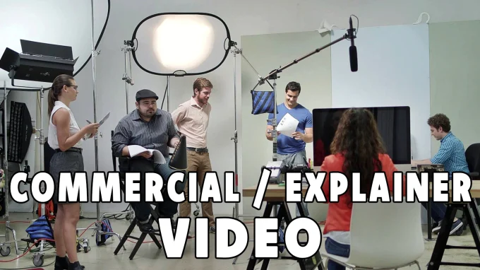 A group of people filming a commercial or explainer video in a studio setup with lighting, camera, and microphones.